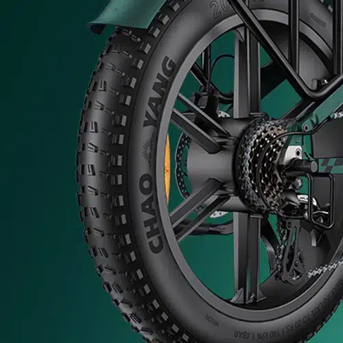 Close-up of a bicycles rear wheel with a thick, knobby tire labeled CHAO YANG. The image also shows the gear cassette, chain, and disc brake against a dark green background.