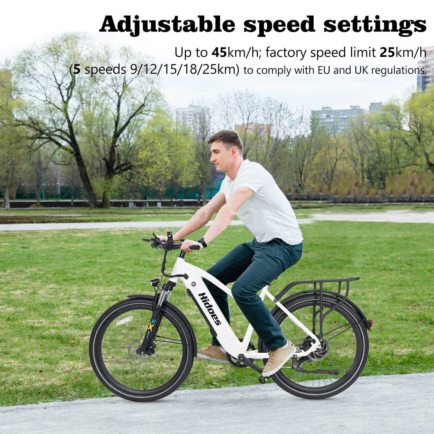 A man rides a white electric bike on a paved path through a park. Tall buildings are visible in the background. Text on the image highlights the bike’s adjustable speed settings up to 45 km/h and compliance with regulations.