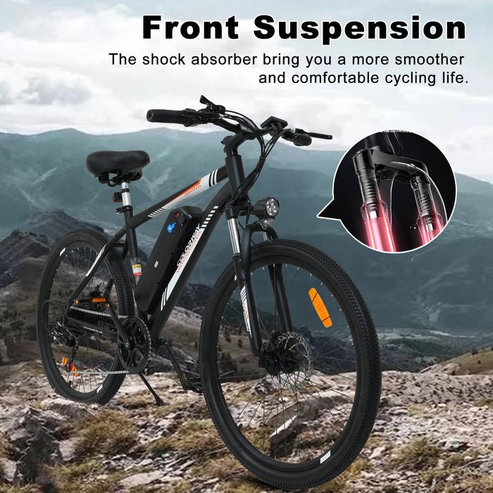 A black mountain bike with front suspension is shown on rocky terrain. An inset highlights the front shock absorbers. Text above describes the benefits of a smoother, more comfortable cycling experience. Mountains are visible in the background.