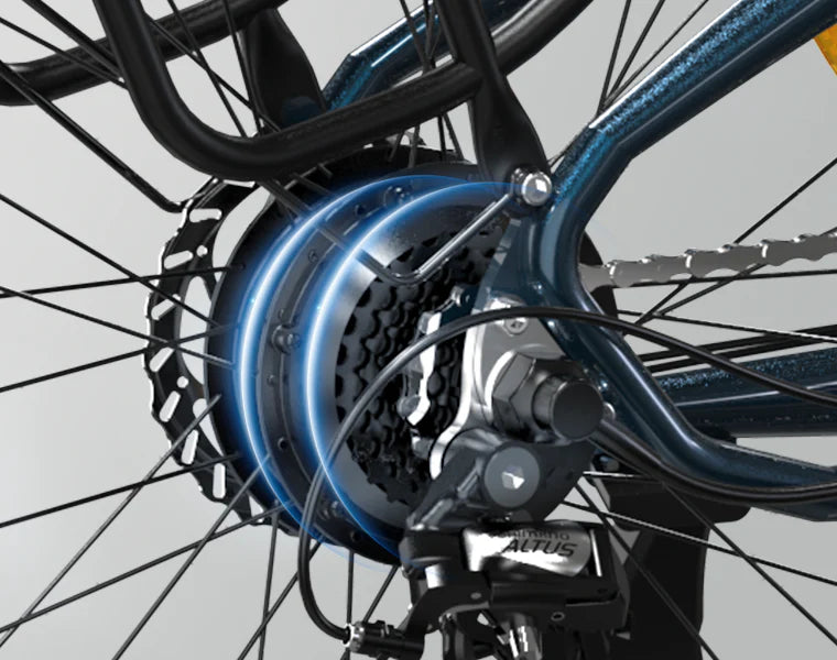 Close-up of a bicycle’s rear wheel showing the gear cassette, derailleur, disc brake rotor, and part of the frame. The image highlights the bikes mechanical components and blue metallic frame.