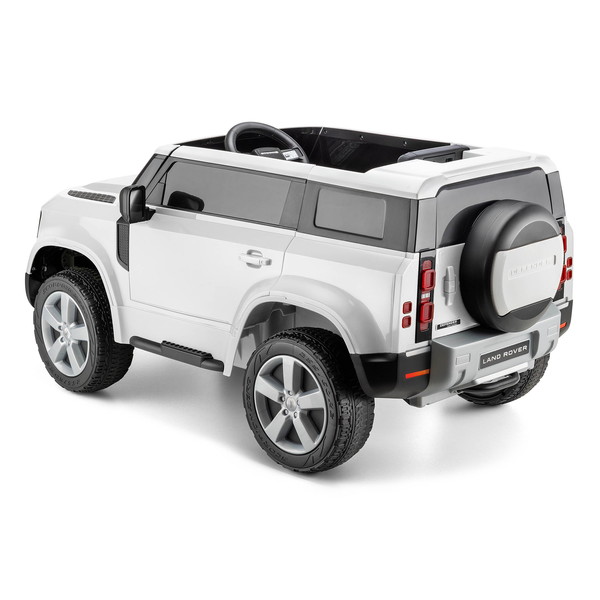 White Land Rover Defender kids electric ride-on car with detailed exterior and rear spare tire on a white background