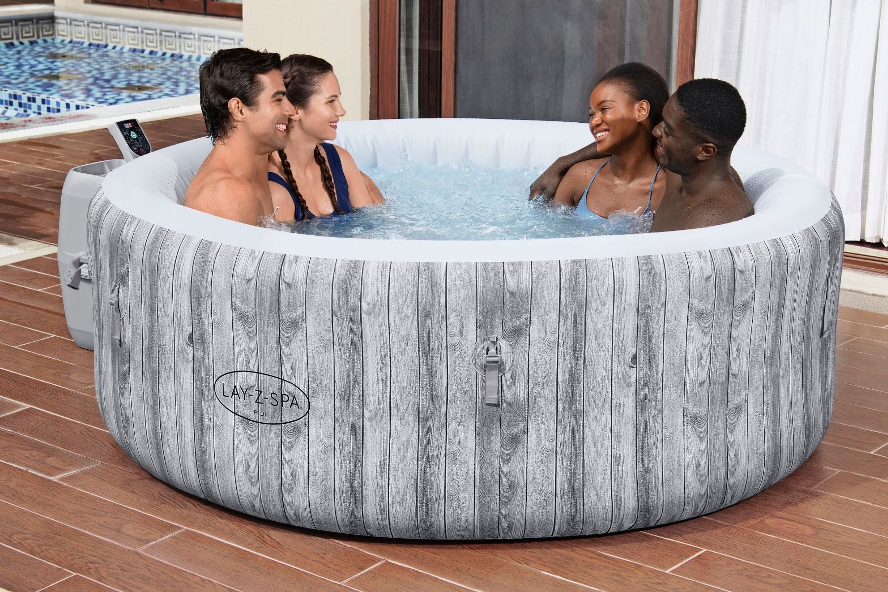 Four adults using the Lay-Z-Spa Fiji AirJet hot tub